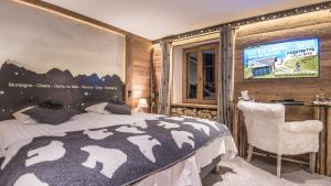 尚佩里Le Chalet de l'Atelier - Le Nord的一间卧室配有一张床,墙上配有电视