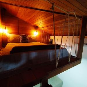 圣若泽Loft encantador D - 8 km de Floripa的卧室配有秋千床。