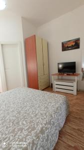 卡塔尼亚Fontanarossa Airport Apartment的一间卧室配有一张床、一个梳妆台和电视。