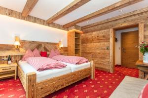 玛丽亚阿尔姆Pension Berghof的一间卧室设有一张床和木墙