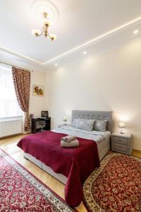 利沃夫Apartment on Tamanskaya 3/4的一间卧室配有一张大床和红色地毯。
