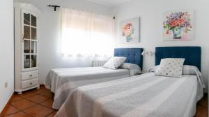 Ortigosa del MonteLa Casita de las Hortensias的一间卧室设有两张床和窗户。