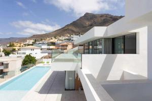 阿德耶New Home Costa Adeje Luxurious Private Villa的一座带游泳池和山脉的白色房子