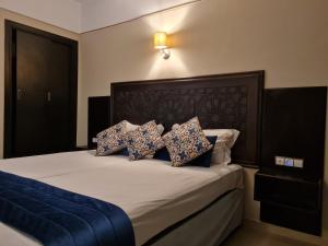 非斯巴塔酒店的一间卧室配有带3个枕头的床