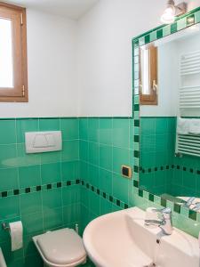 圣玛丽亚巴格诺B&B La Spiaggetta的绿色瓷砖浴室设有卫生间和水槽