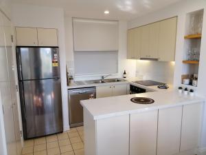 波高尔宾Cypress Lakes Villa Domenica的厨房配有白色橱柜和不锈钢冰箱