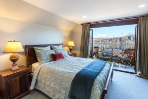 皇后镇斯通里奇村旅馆的一间卧室设有一张床和一个享有美景的大窗户