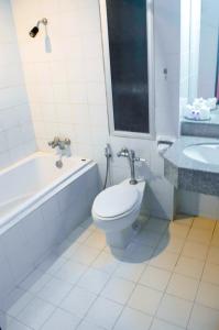 勿洞Sweet Home Hotel Betong的浴室配有卫生间、浴缸和水槽。