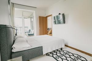 塔尔图ÖÖ Street Luxury Apartment with Terrace的一间卧室配有一张床,墙上配有电视