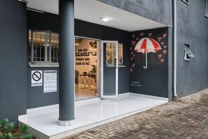 约翰内斯堡Inn & Out Sandton的墙上有红伞的商店前部