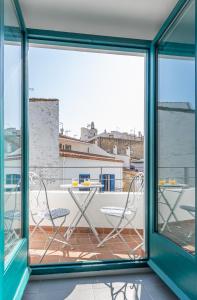卡达克斯Habitacions Bellaire Cadaqués的阳台配有2把椅子和1张桌子。