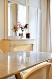 里昂Eden blue, Lovely flat, bright & cosy in Lyon的一张木桌、椅子和鲜花窗户