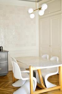 里昂Eden blue, Lovely flat, bright & cosy in Lyon的一间设有白色桌子和白色椅子的用餐室