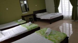 哥打巴鲁Cerana Villa Eco Resort的带三张床和镜子的客房