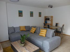 GaukönigshofenExclusive cozy apartment in the heart of Franconia的客厅配有灰色的沙发和桌子