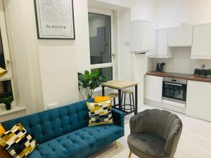 格拉斯哥Cheerful 2 Bedroom Homely Apartment, Sleeps 4 Guest Comfy, 1x Double Bed, 2x Single Beds, Parking, Free WiFi, Suitable For Business, Leisure Guest,Glasgow, Glasgow West End, Near City Centre的客厅配有蓝色的沙发和椅子