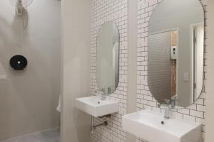 普吉镇THE BELONG BOUTIQUE HOTEL的白色的浴室设有两个盥洗盆和镜子