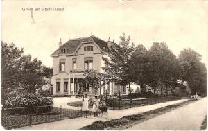 斯塔茨卡纳尔B&B Villa de Beuk的一张房子的旧照片,有两个人站在房子前面