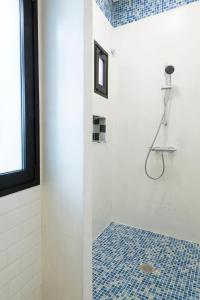 巴尔韦尔德ELHIERRO BED&URBAN I的浴室铺有蓝色瓷砖地板,设有淋浴。