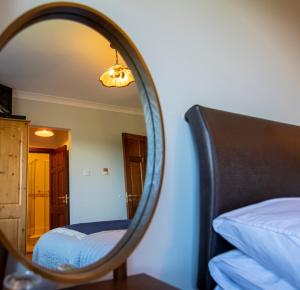本拉提Bunratty Meadows Bed & Breakfast的配有一张床和一张床的客房内的镜子