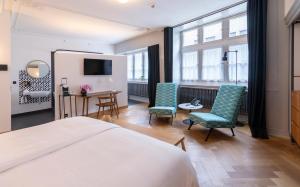 苏黎世马克加赛酒店的一间卧室配有一张床、两把椅子和一张书桌