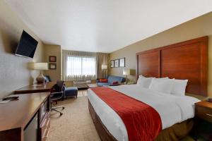 休伦湖河滨康福特茵酒店的酒店客房设有一张大床和一张书桌。