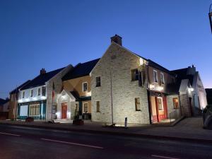 巴利利芬Ballyliffin TownHouse Boutique Hotel的一群晚上在城市街道上建的建筑