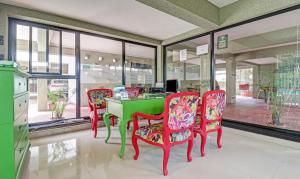 阿伯来Treebo Trend Aquamarine Arpora的一间设有绿色桌子和四把椅子的用餐室