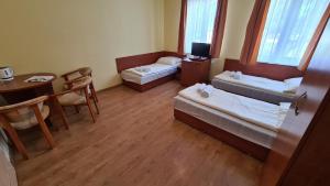 济夫努夫金鱼自然之旅度假酒店的小房间设有两张床、一张桌子和一张桌子。