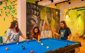 瑞诗凯诗goSTOPS Rishikesh, Lakshman Jhula的三个女孩在一个带台球桌的房间打台球