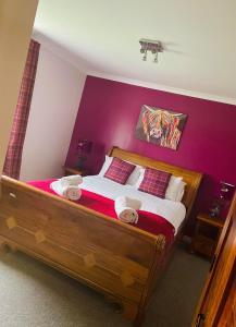 LochgellyRemus B&B的一间卧室设有一张大木床和紫色墙壁