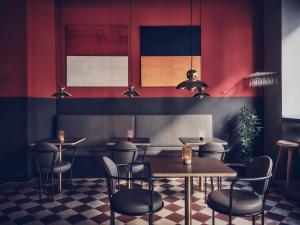 哥德堡弗洛拉酒店的一间带桌椅和红色墙壁的餐厅