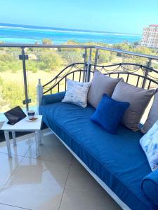 蒙巴萨Nyali Emirates Reef Apartment的海景阳台上的蓝色沙发