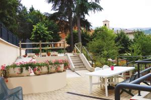拉奎拉Casa Ospitalità San Giuseppe的庭院里种有盆栽植物,设有桌子和楼梯