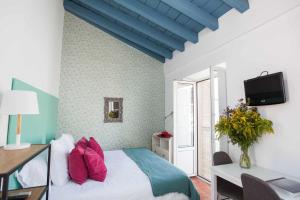 塞维利亚Alojarte Mezquita 5的一间卧室配有带粉红色枕头的床。