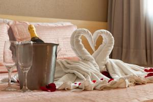 维拉维尔哈Hotel Olympia的一张桌子,配有两条天鹅毛巾和一瓶香槟