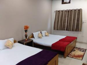 UmariāHotel Jungle Palace Resort的客房设有两张床和窗户。
