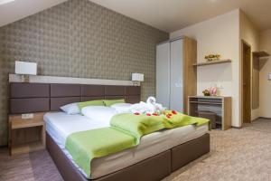 韦赖谢吉哈兹Veres Motel的一间卧室配有一张带绿色和白色床单的大床