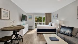 东汉普顿东汉普顿度假屋酒店的酒店客房配有床、桌子和沙发。