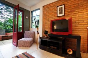蒂拉登特斯Casa charmosa e espaçosa的一间带电视和砖墙的客厅