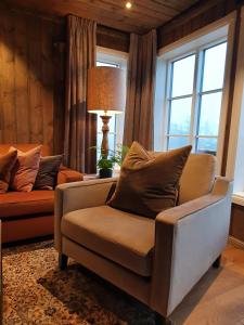 伯New cabin at Lifjell perfectly located for hiking with sauna and ski-in/ski-out的客厅配有椅子、灯和窗户