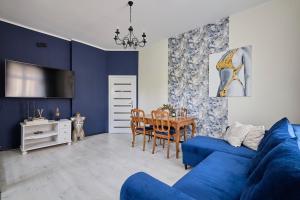 斯扎瓦诺泽德霍Art Apartment Szczawno Zdrój的客厅配有蓝色的沙发和桌子