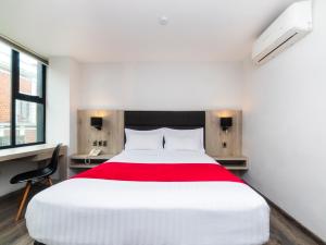 普埃布拉Hotel Nube的卧室配有一张大白色床和红色毯子