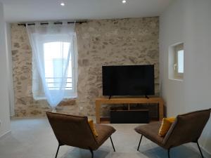 奥尔冈L'envoûtement Provençal, jacuzzi privatif et SPA的一间带电视和两把椅子的客厅