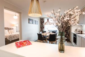 罗瓦涅米Nordica Design Residence Rovaniemi的厨房以及带花瓶桌子的用餐室。