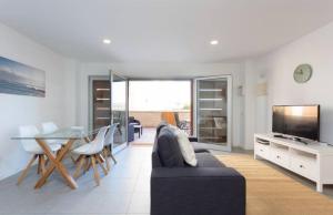 厄尔梅达诺Modern seafront flat with a private garage的带沙发、桌子和电视的客厅