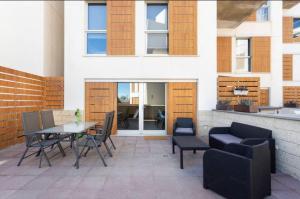 厄尔梅达诺Modern seafront flat with a private garage的一个带桌椅的庭院和一座建筑
