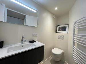里昂Le soyeux的白色的浴室设有水槽和卫生间。
