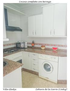 扎哈拉CASA GLADYS的厨房配有白色橱柜和洗衣机。