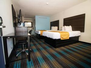 彭萨科拉Sweet Dream Inn - University Park的配有一张床和一张书桌的酒店客房